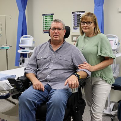 A man in a wheelchair with a woman standing beside him